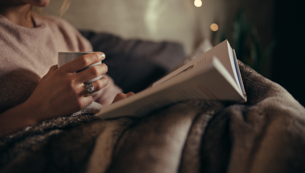 A woman reading a book before going to sleep