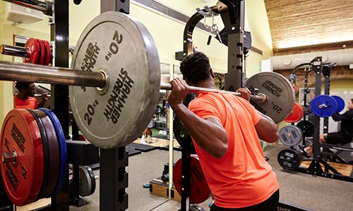 Gym Training - man lifting barbell with heavy weights