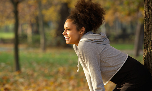 Smiling woman resting in the park after exercise