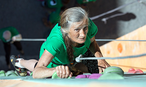 Active older woman rock climbing