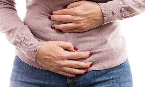 Ovarian cancer - woman holding her bloated stomach