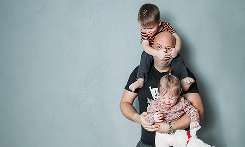 Stressed Dad carrying two children