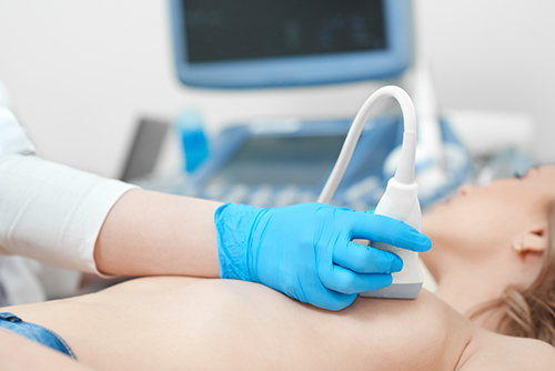 Professional gynecologist performing breast examination for her patient using ultrasound scanner medicine healthcare cancer awareness checkup clinic profession procedure.