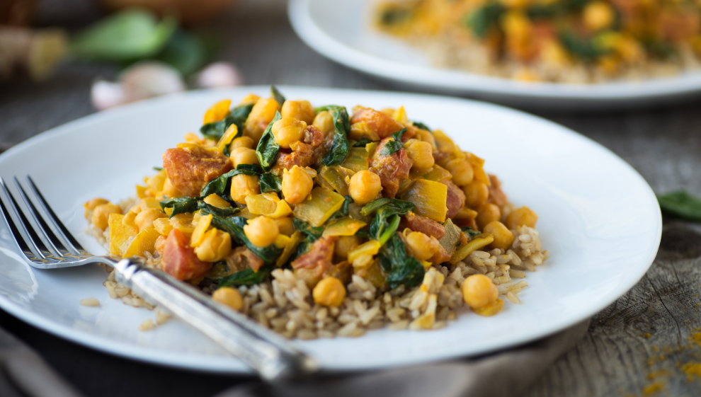 Vegetarian curry with chickpeas, tomato and spinach over brown rice