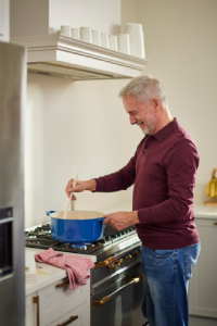 A man in his kitchen washing the dishes