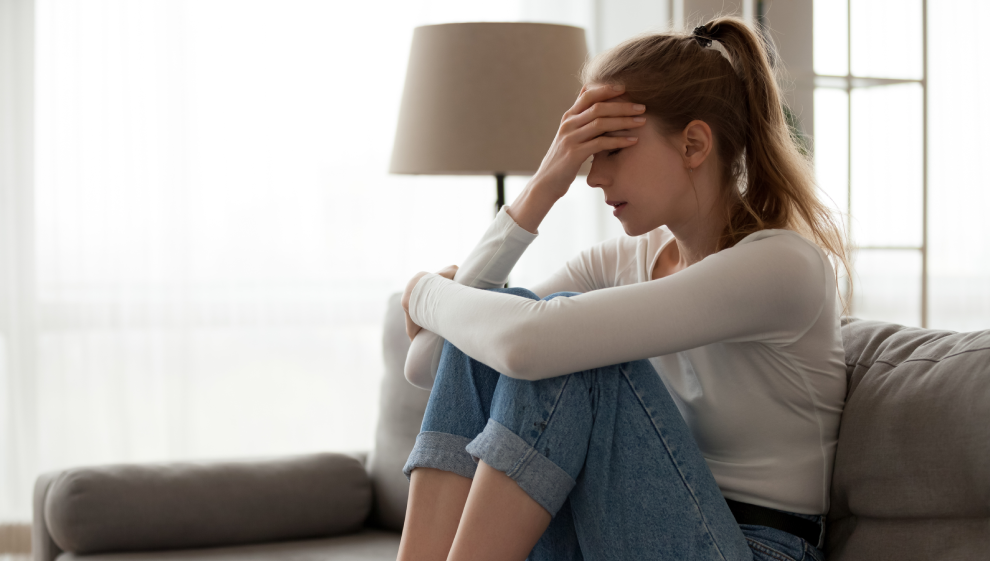 A woman suffering with anxiety sits alone 