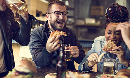 People eating, drinking and laughing in a pub.