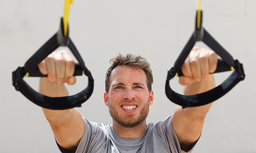 Pulley Workout - man pulling cables towards him with strained face