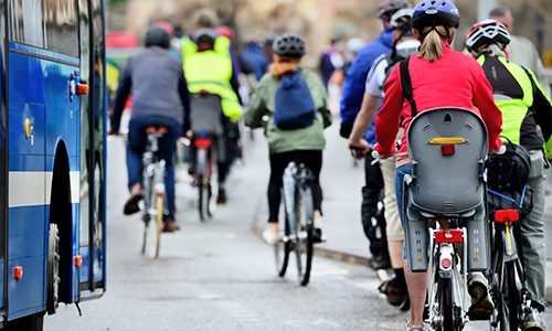 Commuters cycling beside a bus