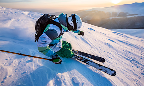 Skiier in white skiing off piste